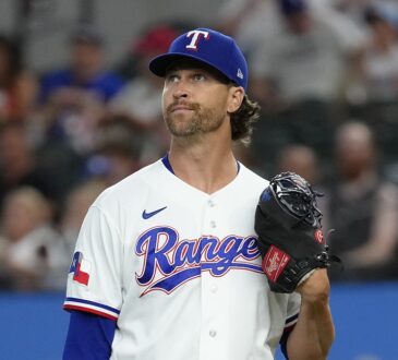 Texas Rangers pitcher Jacob deGrom stands on the mound with his glove up, looking toward the outfield after a strikeout.
