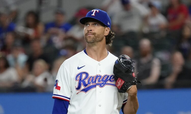 Texas Rangers pitcher Jacob deGrom stands on the mound with his glove up, looking toward the outfield after a strikeout.