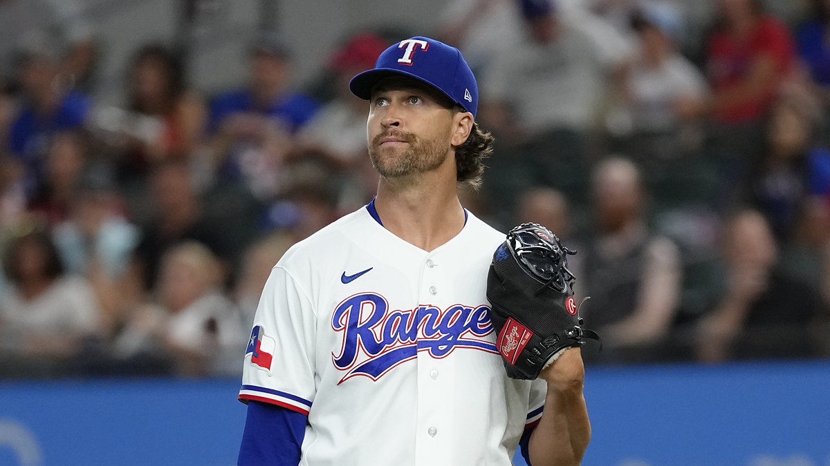 Texas Rangers pitcher Jacob deGrom stands on the mound with his glove up, looking toward the outfield after a strikeout.