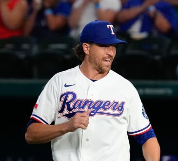 Texas Rangers pitcher Jacob deGrom jogs out to the mound in his white home uniform, smiling.