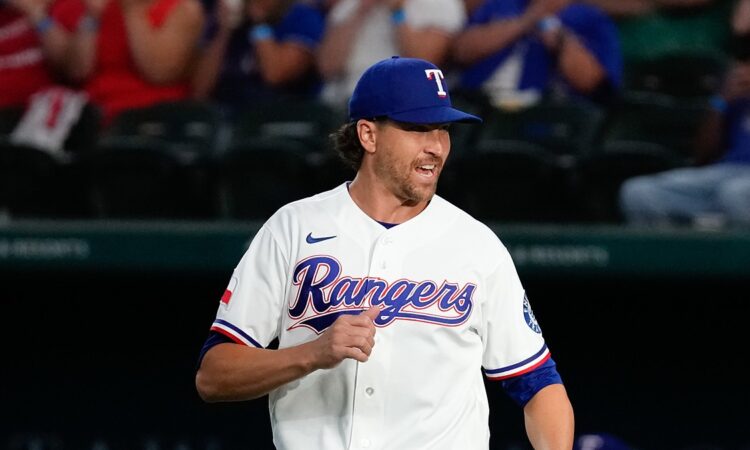 Texas Rangers pitcher Jacob deGrom jogs out to the mound in his white home uniform, smiling.
