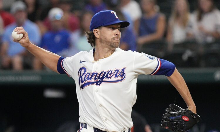 Rangers pitcher Jacob deGrom releases a pitch from the mound in a home white uniform