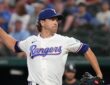 Texas Rangers pitcher Jacob deGrom raises the ball in his right hand as he drives toward the plate in his delivery.