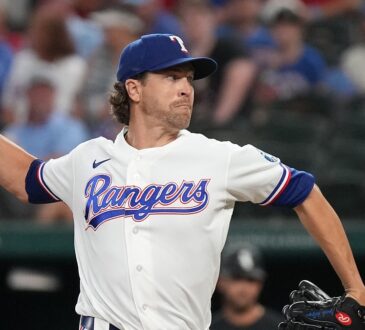 Texas Rangers pitcher Jacob deGrom raises the ball in his right hand as he drives toward the plate in his delivery.
