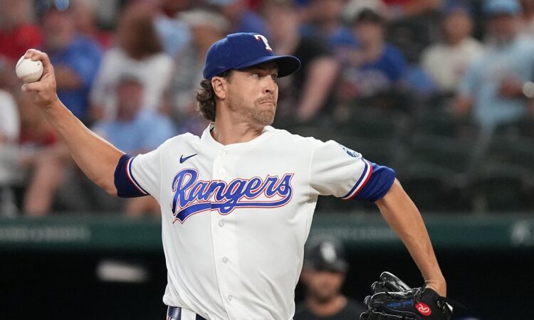 Texas Rangers pitcher Jacob deGrom raises the ball in his right hand as he drives toward the plate in his delivery.