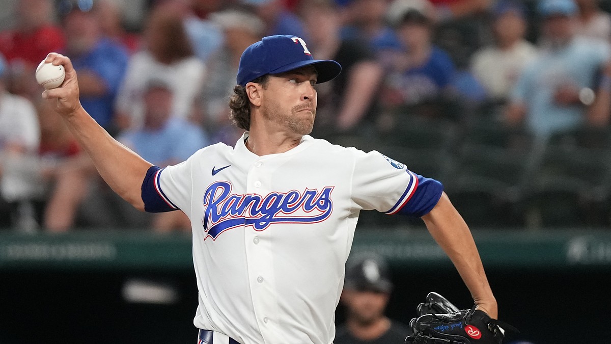 Texas Rangers pitcher Jacob deGrom raises the ball in his right hand as he drives toward the plate in his delivery.