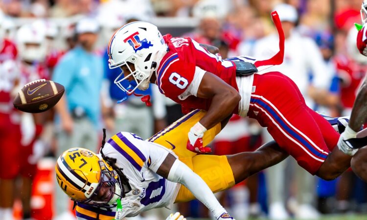 Louisiana Tech defensive back Jacob Fields dives into LSU wide receiver Zavion Thomas, knocking the ball loose.