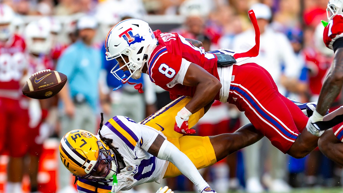Louisiana Tech defensive back Jacob Fields dives into LSU wide receiver Zavion Thomas, knocking the ball loose.