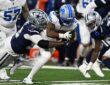 Detroit Lions running back Jahmyr Gibbs is wrapped up by Dallas Cowboys defensive tackle Quinnen Williams on a run.