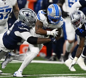 Detroit Lions running back Jahmyr Gibbs is wrapped up by Dallas Cowboys defensive tackle Quinnen Williams on a run.