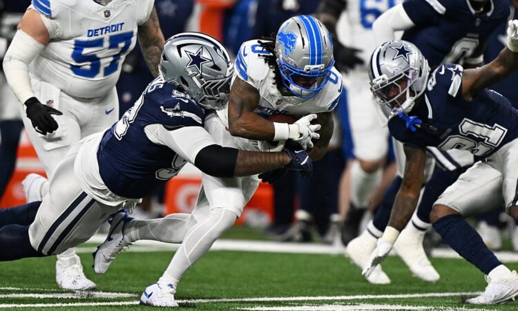 Detroit Lions running back Jahmyr Gibbs is wrapped up by Dallas Cowboys defensive tackle Quinnen Williams on a run.