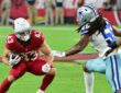 Dallas Cowboys linebacker Jaishawn Barham reaches for Cardinals running back Evan Hull on a first-half carry.