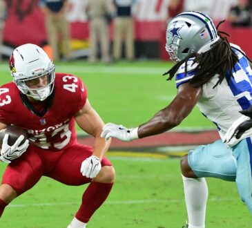 Dallas Cowboys linebacker Jaishawn Barham reaches for Cardinals running back Evan Hull on a first-half carry.