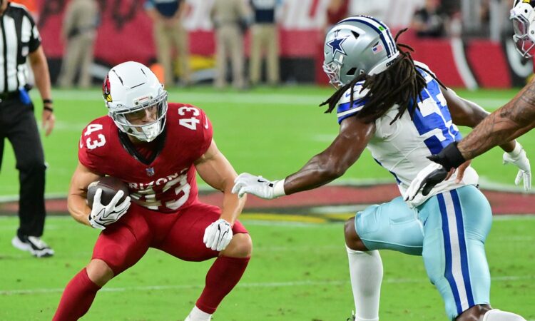 Dallas Cowboys linebacker Jaishawn Barham reaches for Cardinals running back Evan Hull on a first-half carry.