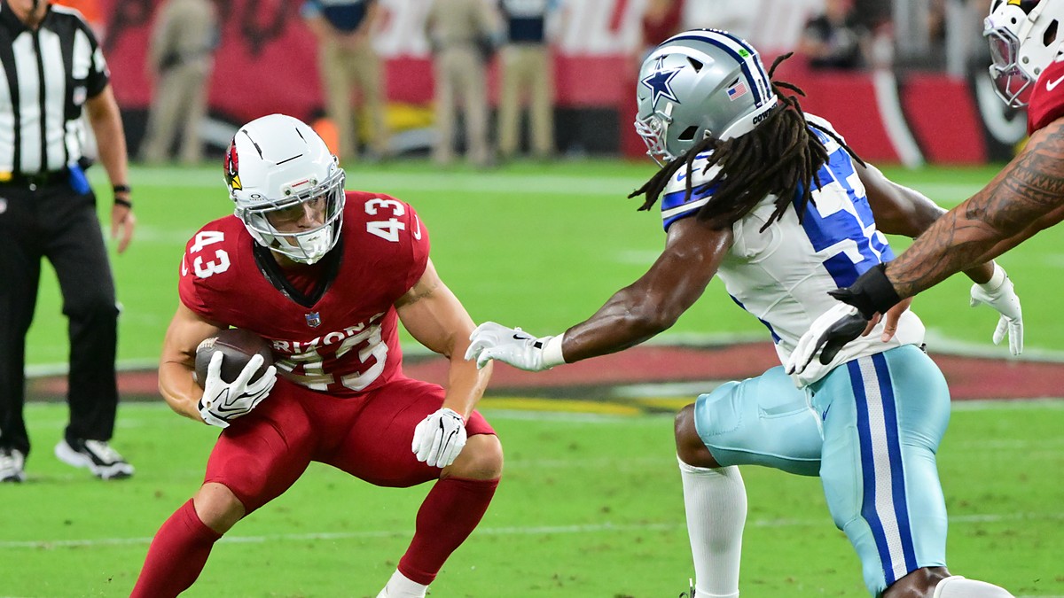 Dallas Cowboys linebacker Jaishawn Barham reaches for Cardinals running back Evan Hull on a first-half carry.