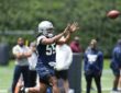 Dallas Cowboys linebacker Jaishawn Barham reaches out to catch a football during a rookie minicamp drill.