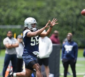 Dallas Cowboys linebacker Jaishawn Barham reaches out to catch a football during a rookie minicamp drill.