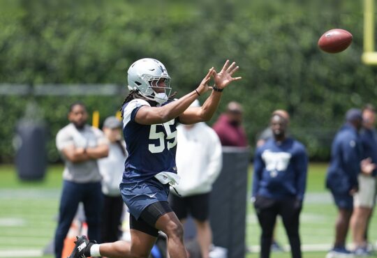 Dallas Cowboys linebacker Jaishawn Barham reaches out to catch a football during a rookie minicamp drill.