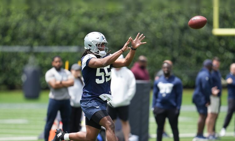 Dallas Cowboys linebacker Jaishawn Barham reaches out to catch a football during a rookie minicamp drill.