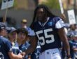 Dallas Cowboys linebacker Jaishawn Barham greets young fans lined up along the sideline at training camp.