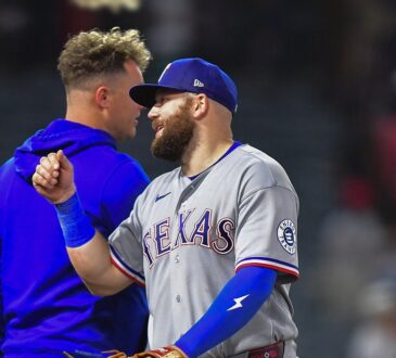 Texas Rangers first baseman Jake Burger smiles and bumps fists with a teammate after a win at Angel Stadium.
