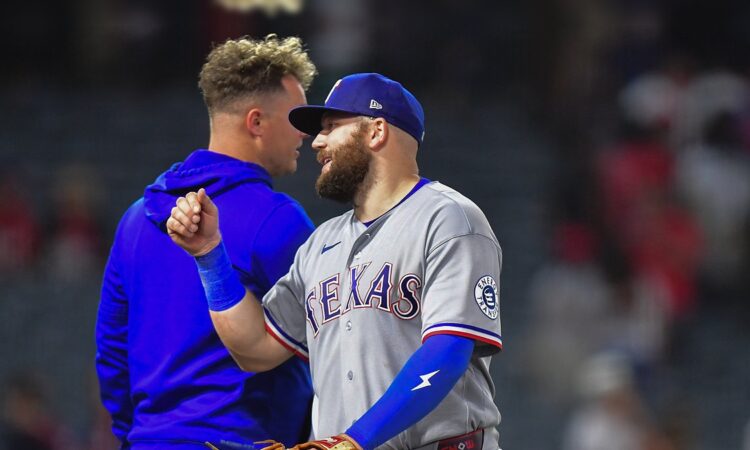 Texas Rangers first baseman Jake Burger smiles and bumps fists with a teammate after a win at Angel Stadium.
