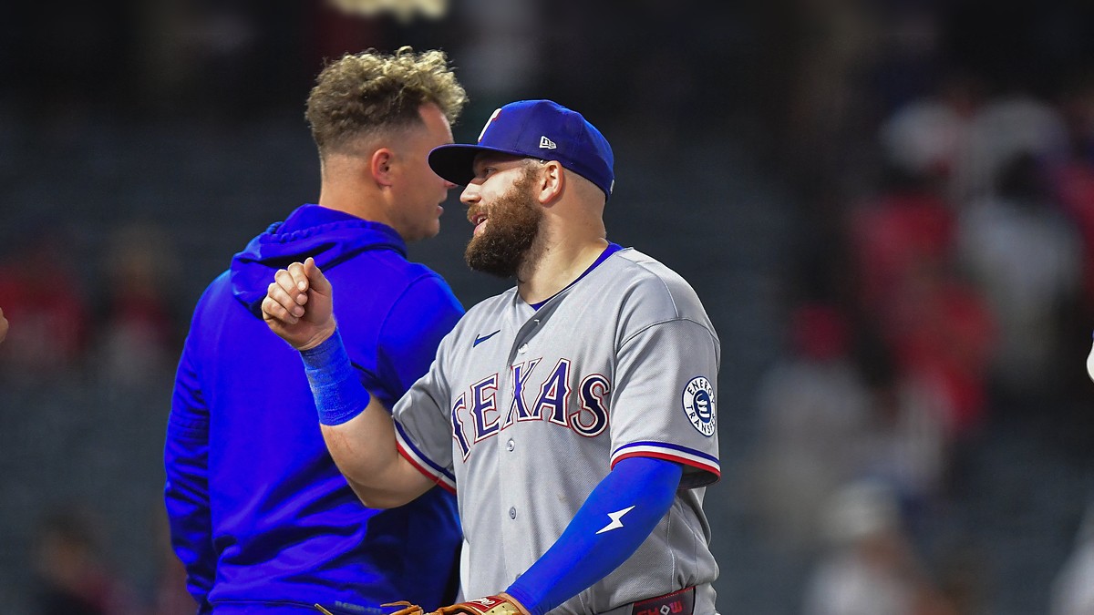 Texas Rangers first baseman Jake Burger smiles and bumps fists with a teammate after a win at Angel Stadium.
