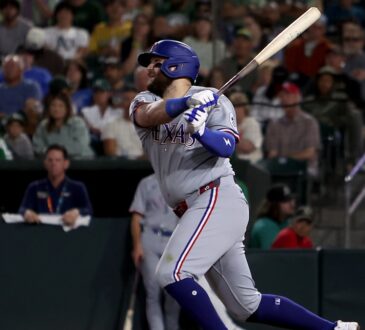 Texas Rangers first baseman Jake Burger follows through on his swing after connecting against the Athletics.