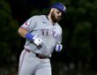 Texas Rangers first baseman Jake Burger rounds the bases in a road gray uniform after a three-run home run.