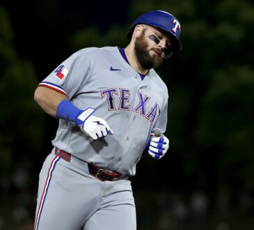 Texas Rangers first baseman Jake Burger rounds the bases in a road gray uniform after a three-run home run.