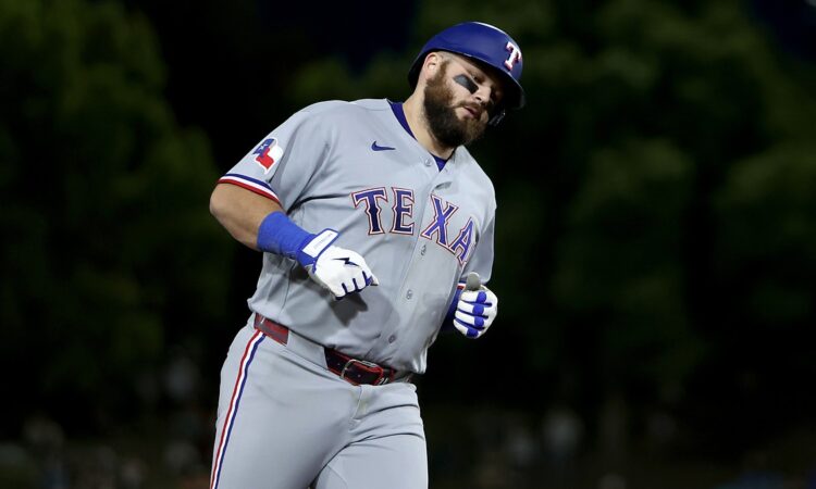 Texas Rangers first baseman Jake Burger rounds the bases in a road gray uniform after a three-run home run.
