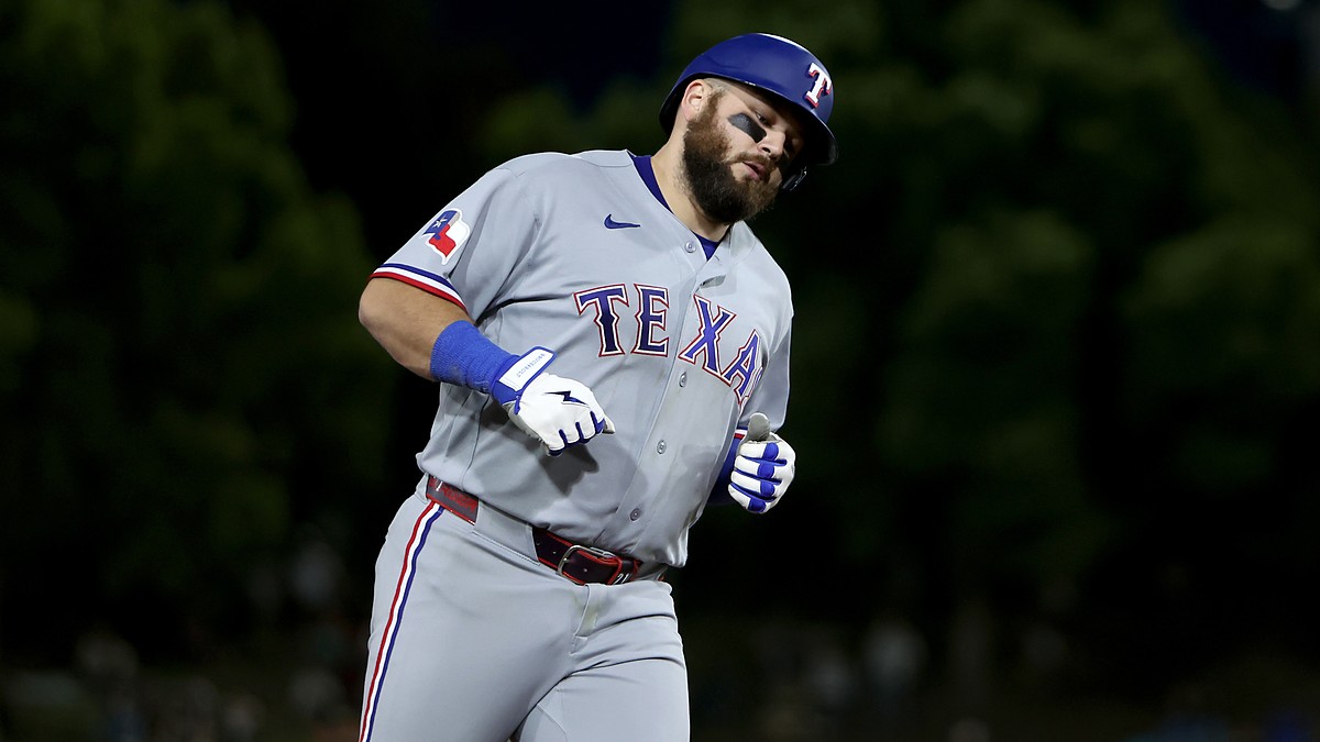 Texas Rangers first baseman Jake Burger rounds the bases in a road gray uniform after a three-run home run.