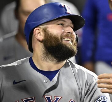 Texas Rangers first baseman Jake Burger smiles in the dugout after a home run against the White Sox.