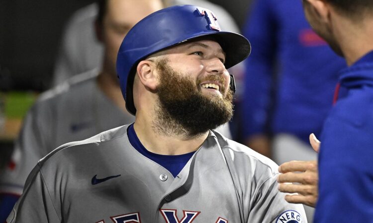 Texas Rangers first baseman Jake Burger smiles in the dugout after a home run against the White Sox.