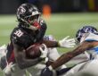 Atlanta Falcons running back Jashaun Corbin secures the football as two Tennessee Titans defenders close in.