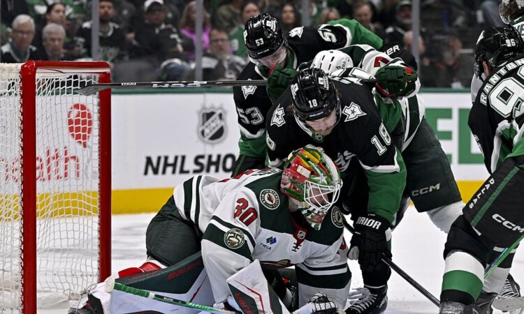 Minnesota Wild goaltender Jesper Wallstedt smothers the puck as Dallas Stars center Sam Steel crashes the net.