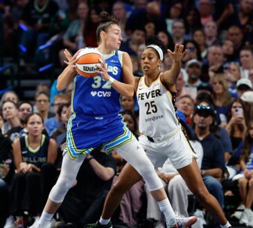 Dallas Wings forward Jessica Shepard secures the ball as Indiana Fever forward Monique Billings defends with both hands up.