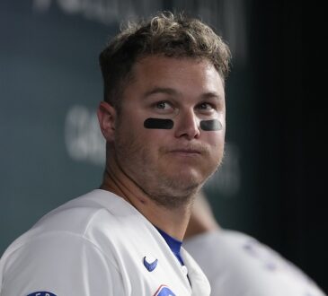 Texas Rangers designated hitter Joc Pederson stands in the dugout in eye black at Globe Life Field.