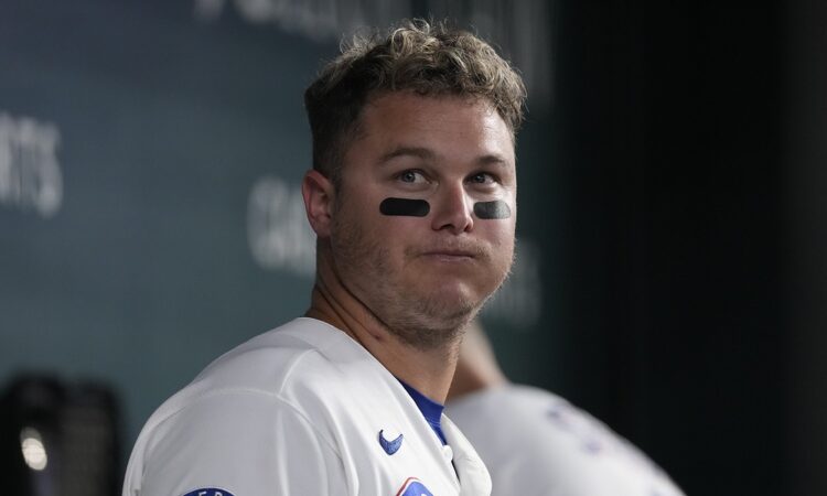 Texas Rangers designated hitter Joc Pederson stands in the dugout in eye black at Globe Life Field.