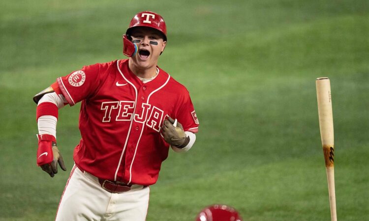 Texas Rangers designated hitter Joc Pederson shouts and flips his bat after connecting on a home run.