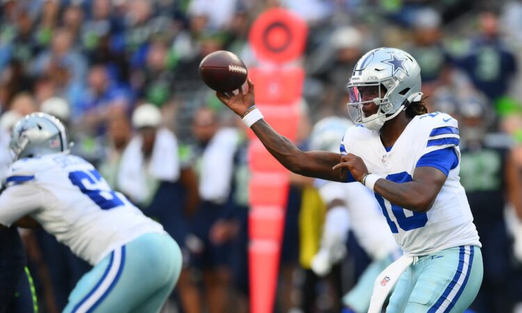 Dallas Cowboys quarterback Joe Milton III cocks the ball to throw as a lineman blocks in front of him.