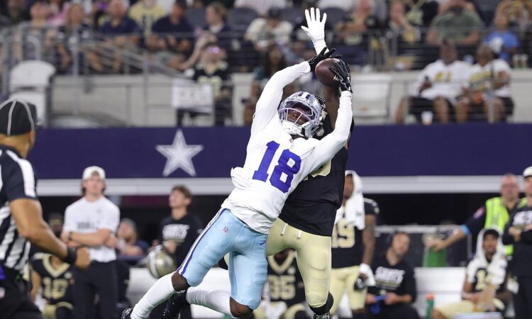 Dallas Cowboys wide receiver Jordan Hudson stretches to make a catch over a New Orleans Saints defender.