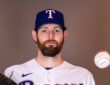 Texas Rangers pitcher Jordan Montgomery holds his glove and tosses a baseball during a media day portrait.