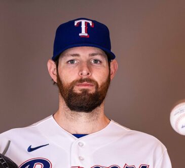 Texas Rangers pitcher Jordan Montgomery holds his glove and tosses a baseball during a media day portrait.
