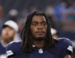 Dallas Cowboys safety Julius Wood walks off the field carrying his helmet after a game.
