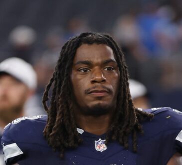 Dallas Cowboys safety Julius Wood walks off the field carrying his helmet after a game.