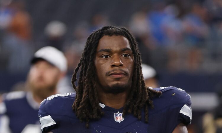 Dallas Cowboys safety Julius Wood walks off the field carrying his helmet after a game.