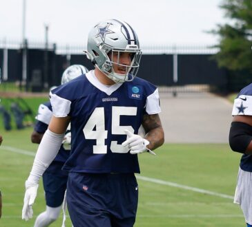 Dallas Cowboys linebacker Justin Barron jogs between drills in a navy practice jersey at the team training facility.