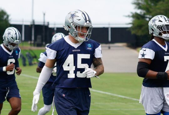 Dallas Cowboys linebacker Justin Barron jogs between drills in a navy practice jersey at the team training facility.