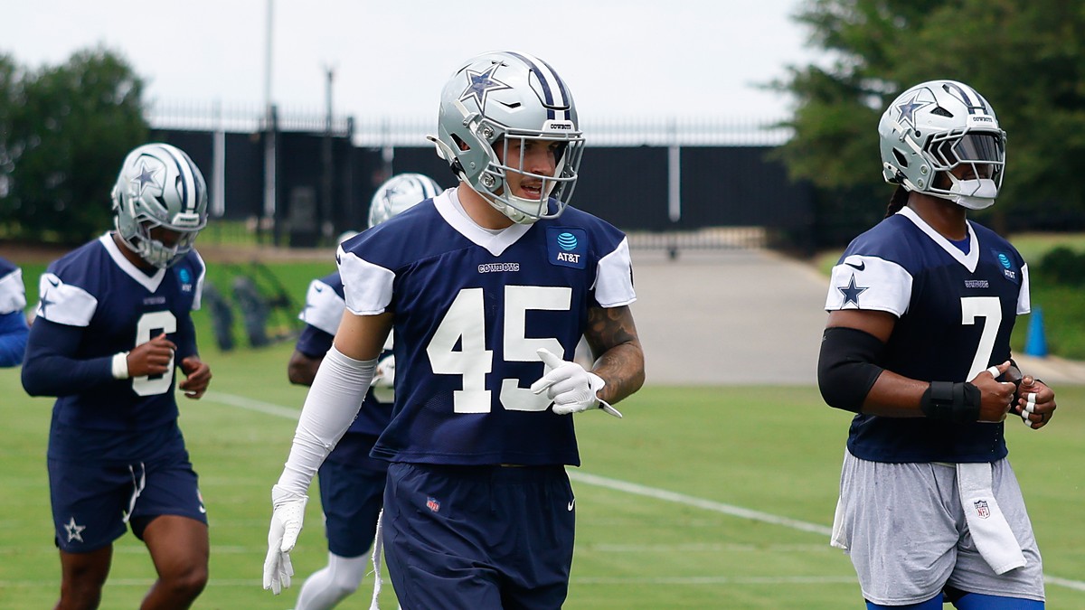 Dallas Cowboys linebacker Justin Barron jogs between drills in a navy practice jersey at the team training facility.